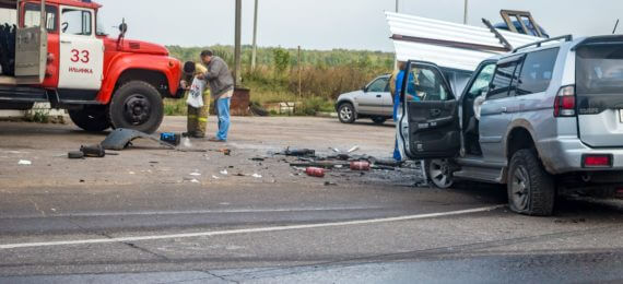 acidente entre dois carros com diversos estilhaçoes na estrada e um caminhão do corpo de bombeiros dando assistência