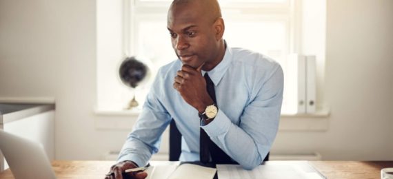 homem de roupa social utilizando um laptop