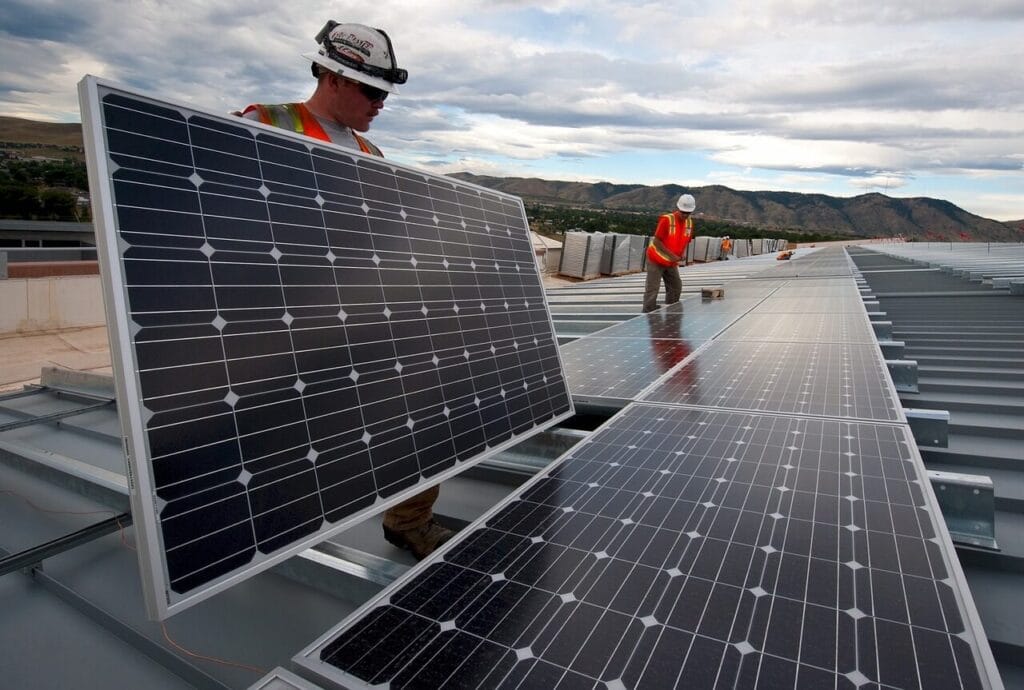 Funcionários fazendo a instalação de painéis solares