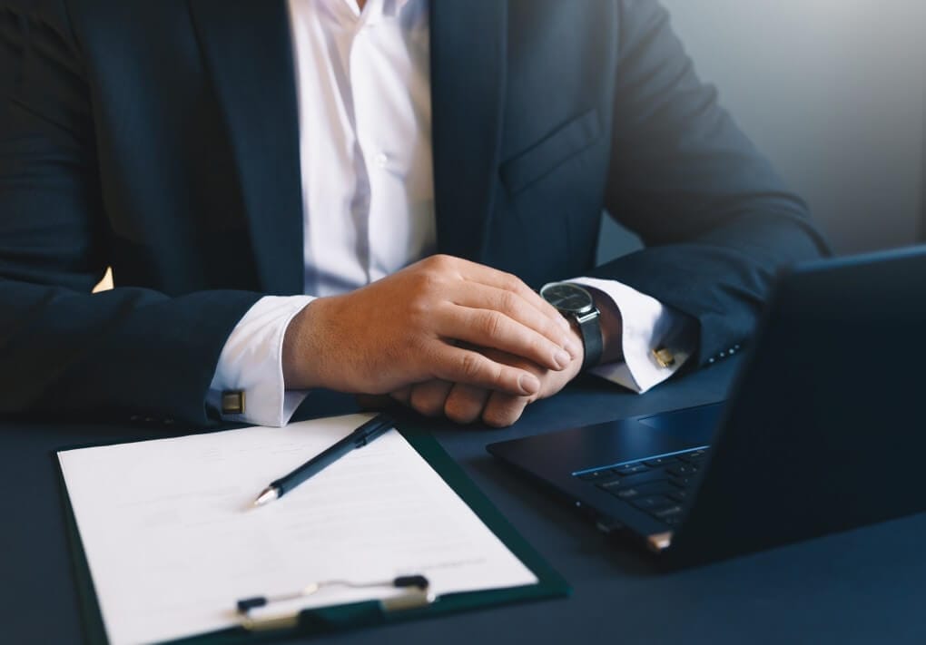 Suspensão do contrato de trabalho - homem com um contrato e um notebook em uma mesa